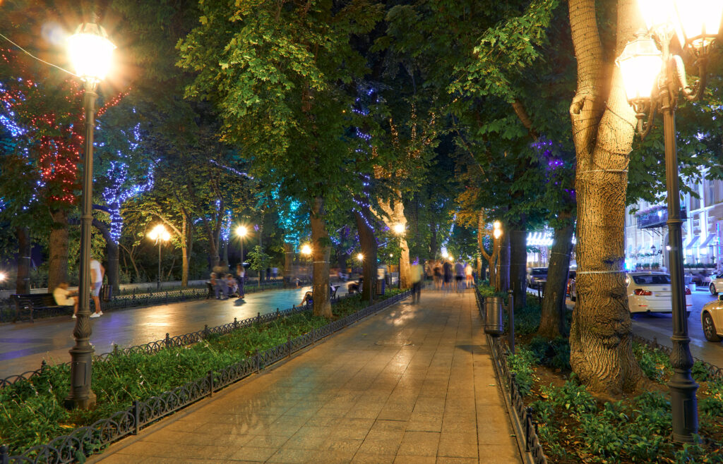 night view of Primorsky boulevard in Odessa city, Ukraine. Beautiful city Park and street illumination, walking people