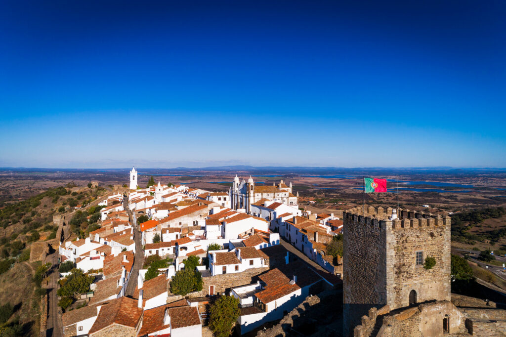 Aerial view of the historic village of Monsaraz in Alentejo with the Alqueva dam reservoir on the background; Concept for travel in Portugal and Alentejo and most beautiful places in Portugal