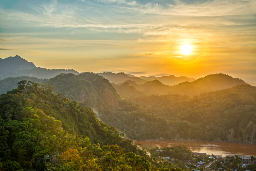 unset over lush green jungle covered hills with the Beni River visible in Rurrenabaque, Bolivia
