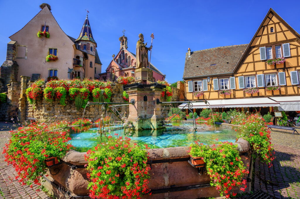 View of the old traditional houses decorated with flowers in alsacian village near Colmar, France